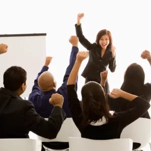 Grupo de personas levantando el puño como símbolo de motivación y participación en programas de capacitación y bienestar