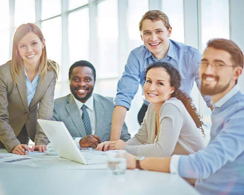 Equipo de trabajo reunido en una mesa fomentando la comunicación en el entorno organizacional.