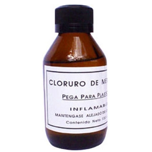 Botella de cloruro con advertencias visibles en la etiqueta.