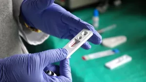 Persona sosteniendo una prueba rápida de detección de VIH como parte del cumplimiento en salud ocupacional
